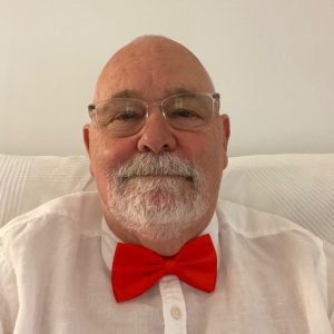 Simon Randerson smiling, wearing a red bow tie