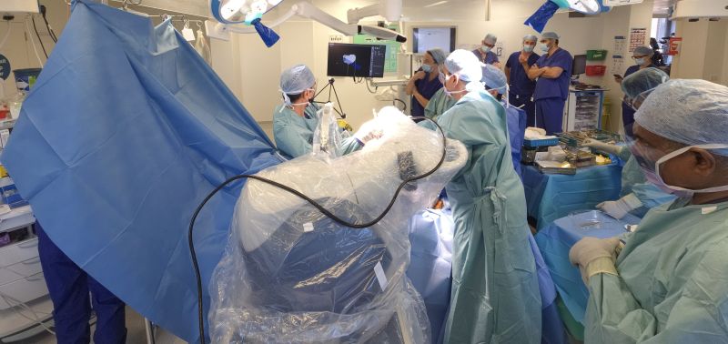 A shot of the operating thetre, with staff in scrubs working alongside the robot